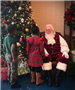 Boy and girl talking to Santa Claus.