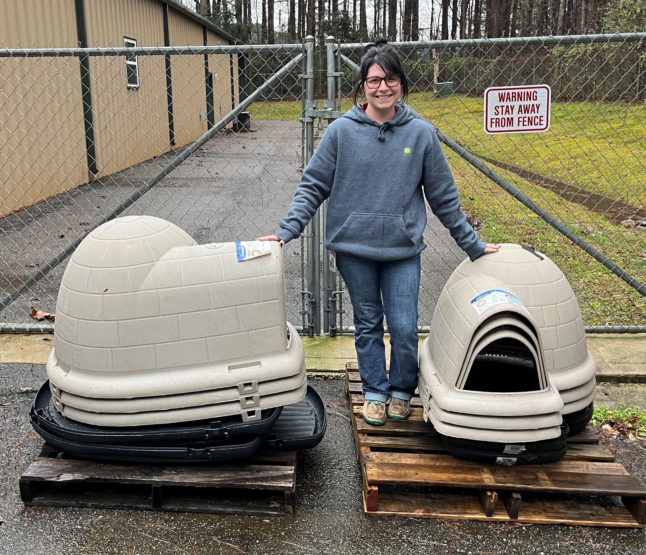Woman standing between Igloo Shaped Dog Houses