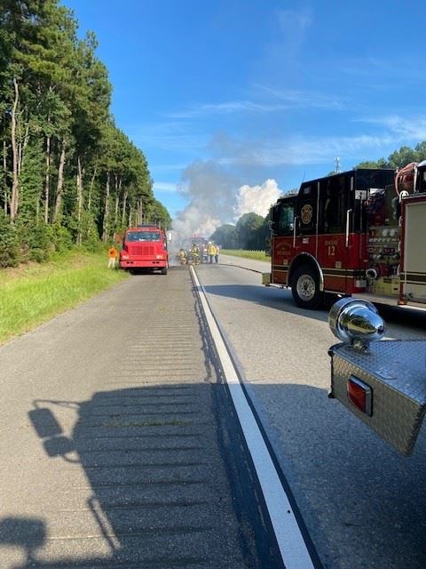 Vehicle Fire on the side of the interstate. Fire trucks on scene.