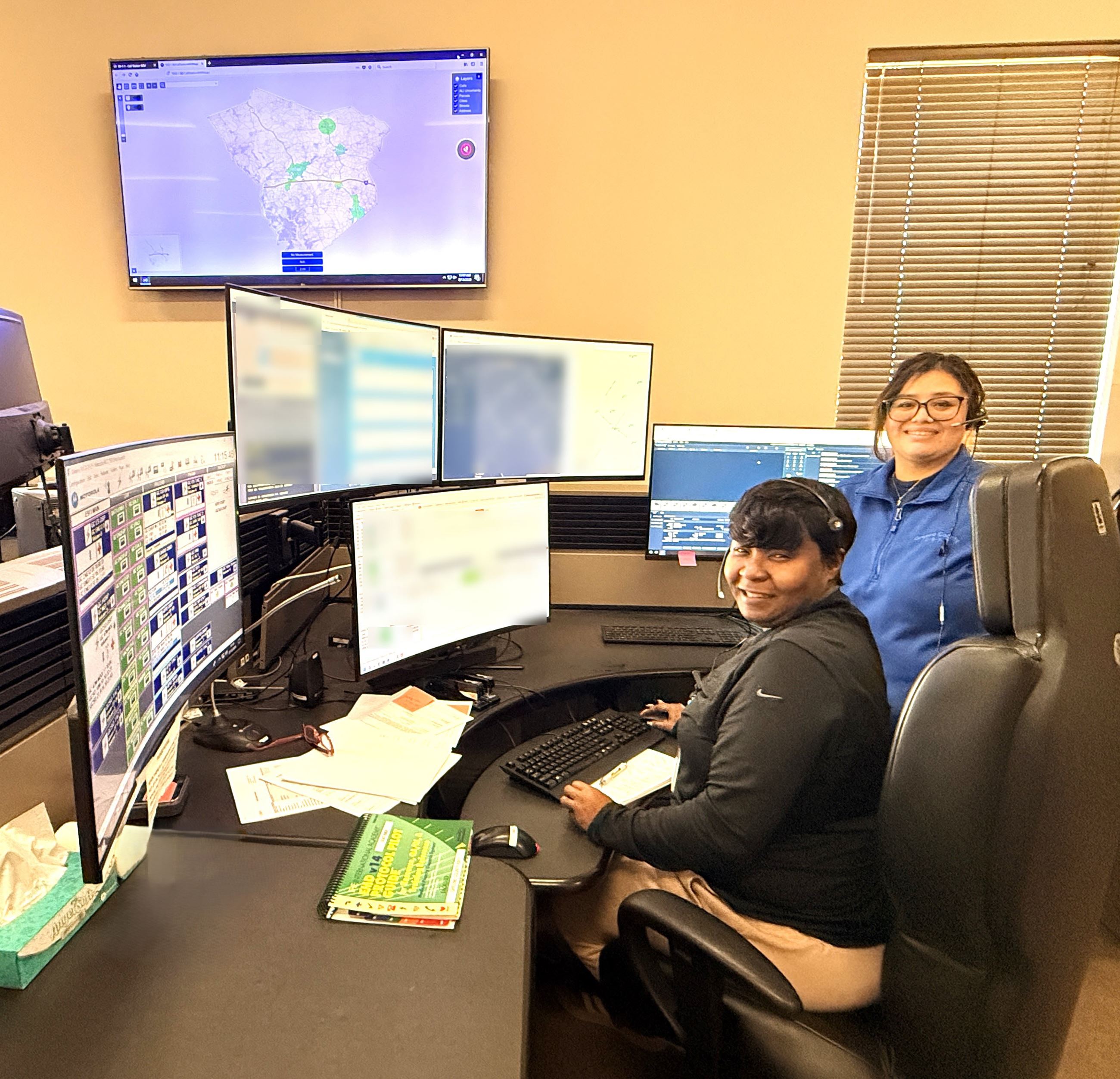 L-R Cole Armour and Anakaren Pena in front of dispatch monitors